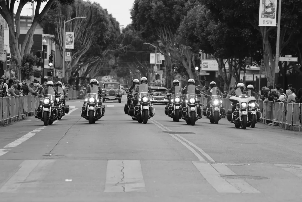 Police motorcycle escort leading a motorcade through a city street