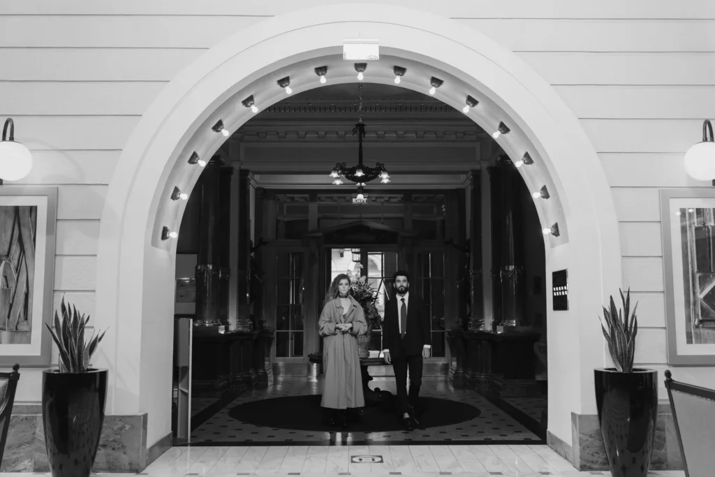 Guests at the arched entrance of a hotel