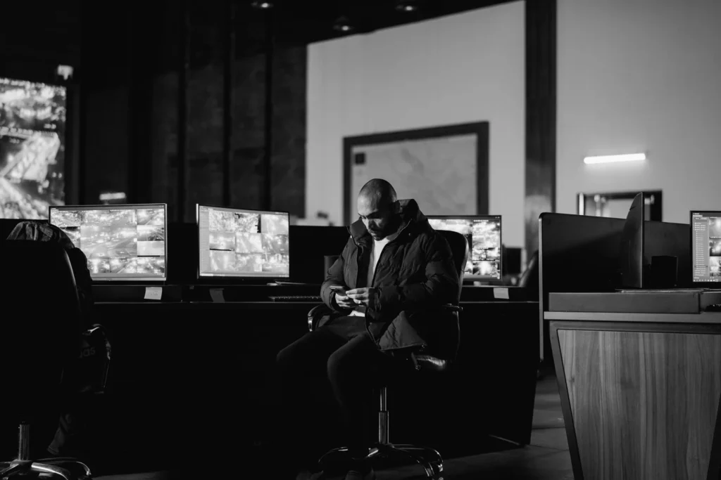 Security officer at a desk in a control room with surveillance monitors