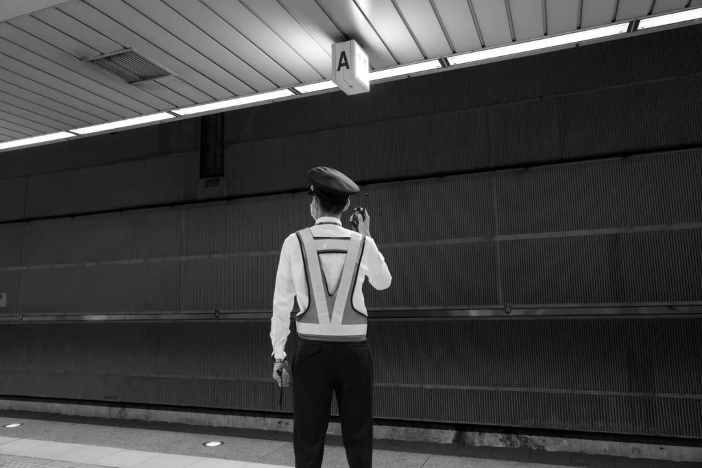Security officer using a radio on a transit platform