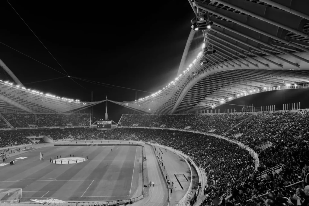 Stadium filled with fans under floodlights at night
